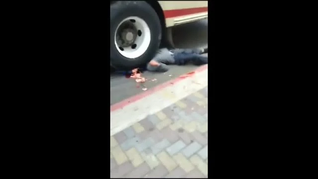 A Motorcycle Is Crushed By The Front Wheel Of A Bus, The Motorcyclist's Head Is Crushed By The Rear Wheel